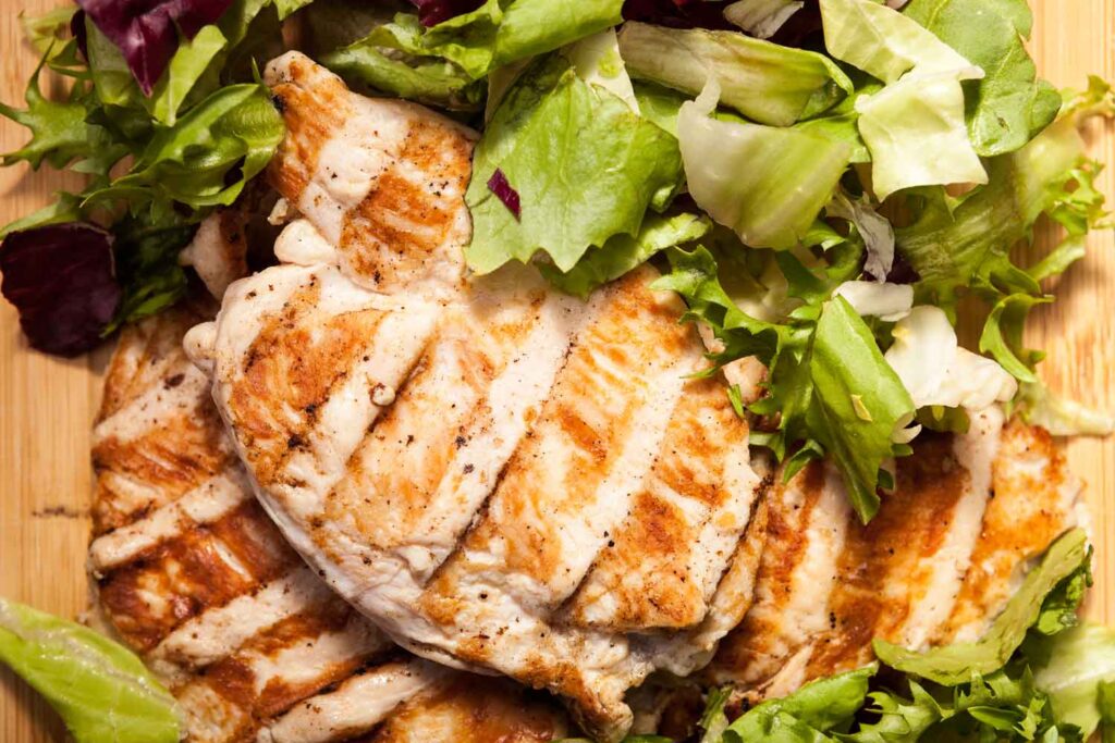 close-up-grilled-chicken-breast-fresh-cut-salad-bunch-tomatoes-wooden-board
